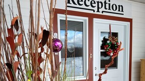 A reception area with a sign, a wreath, and decorative plants. - Wayside Motel Manitoulin (Assiginack)