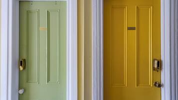 Two doors, one green and one yellow, with a white frame and a small sign on each.