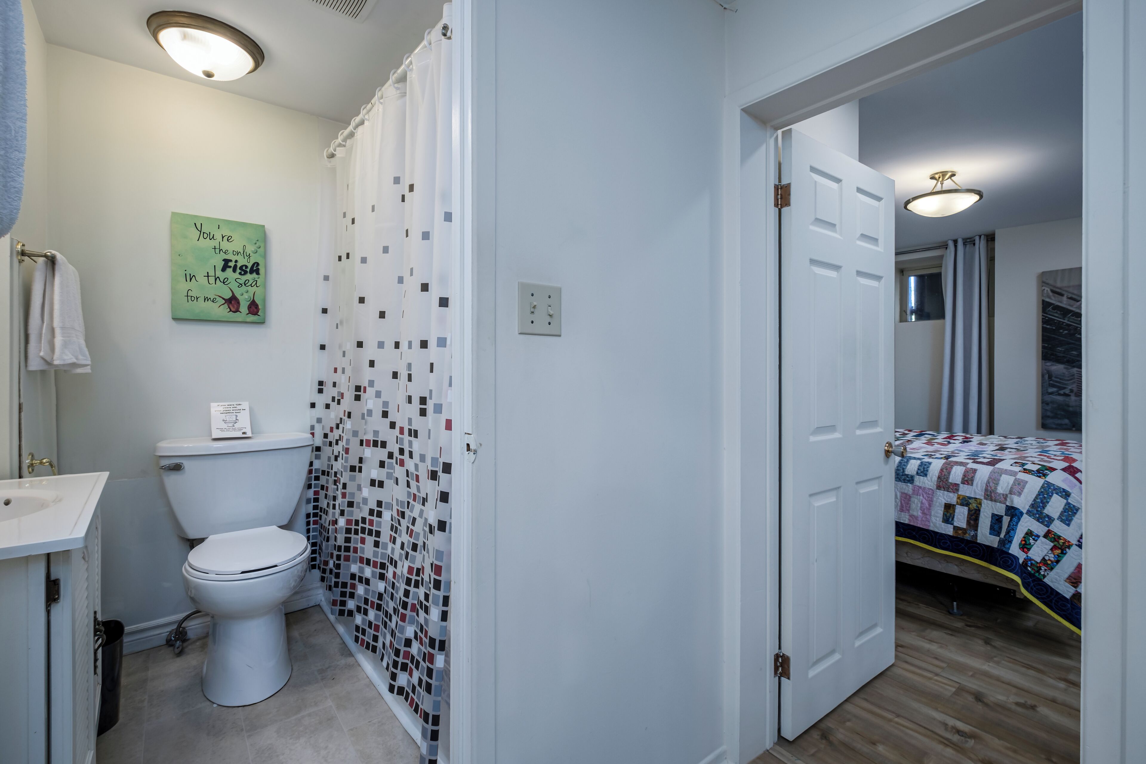 A bathroom with a toilet, sink, and shower curtain.