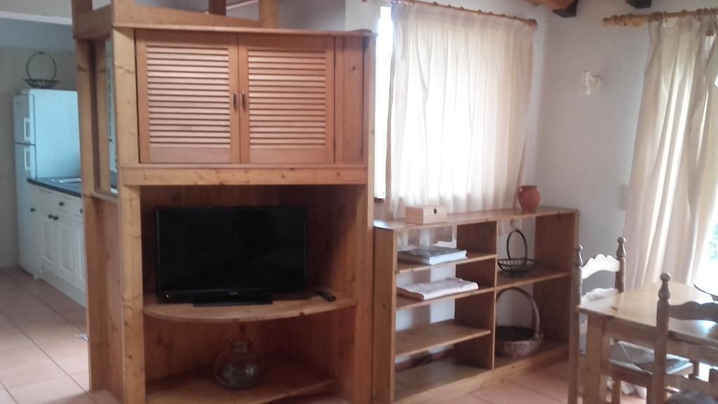 Un mueble de madera con televisor, estantes y una mesita.