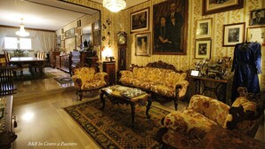 Un salon traditionnel agrémenté d’un lustre, d’un papier peint à motifs et de meubles classiques.
