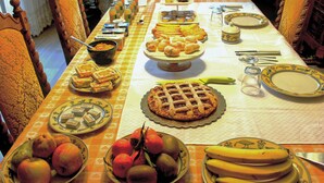 Une table dressée pour un repas, avec différents plats et des fruits.