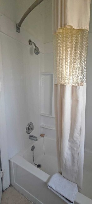 Een badkamer met een badkuip, douche en gordijn.