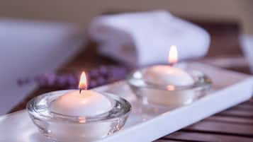 Two lit candles in glass holders on a white tray.