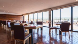 A restaurant with wooden flooring, large windows, and a view of the cityscape. - Can Bonastre Wine Resort, The Originals Relais (Relais du Silence) (Masquefa)