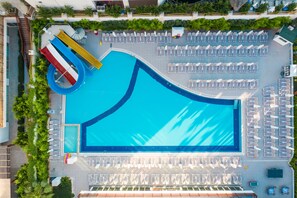An aerial view of a swimming pool with multiple lanes, surrounded by rows of sun loungers and umbrellas. - Side Royal Palace Hotel & Spa - All Inclusive (Manavgat)