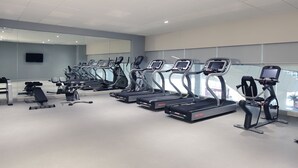 A gym with multiple treadmills, weight machines, and a large mirror wall. - Holiday Inn Express New Delhi International Airport T3 by IHG (New Delhi)