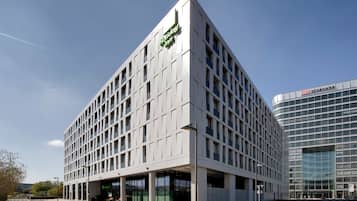 Ein modernes Gebäude mit einem Holiday Inn-Schild, das ein Fenstergitter und eine glatte Fassade zeigt.