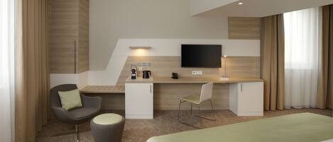 A modern hotel room with a bed, a desk with a flat-screen TV, a chair, a small cabinet, and a coffee machine.