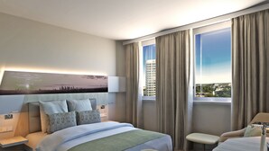 A hotel room with a large bed, a bedside table, a nightstand, a window with curtains, and a cityscape view.