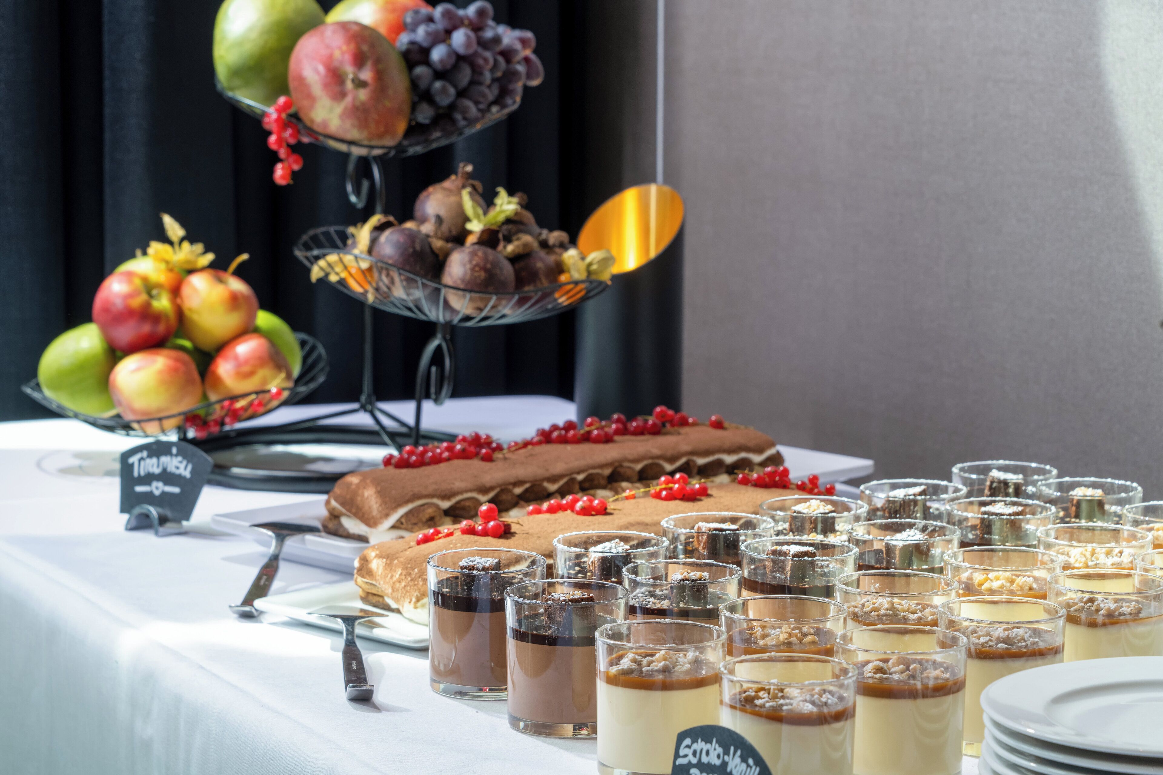 Una mesa de buffet con diversos postres y frutas.