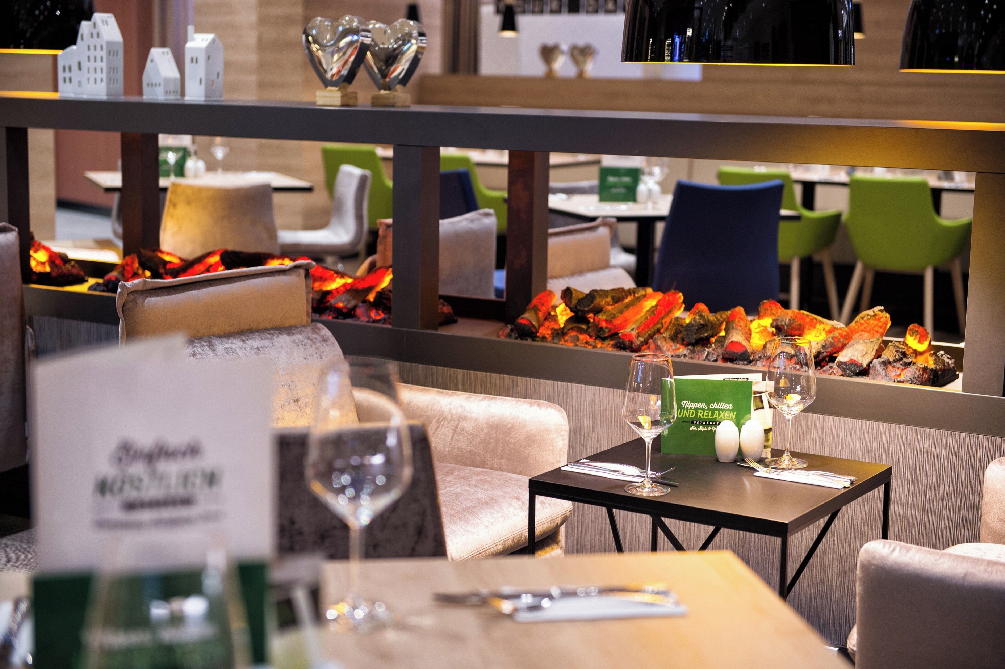 A restaurant setting with a table set for dining, including a menu, a glass of water, and a wine glass.