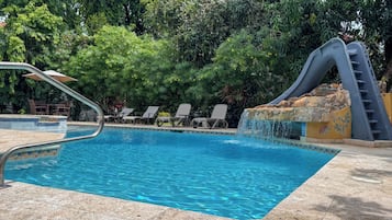 Una piscina al aire libre, sombrillas, tumbonas