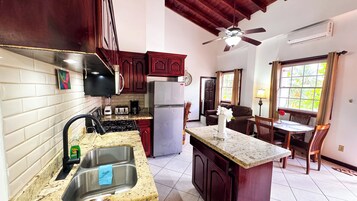 Una cocina equipada con fregadero, estufa, refrigerador y un comedor con mesa y sillas.
