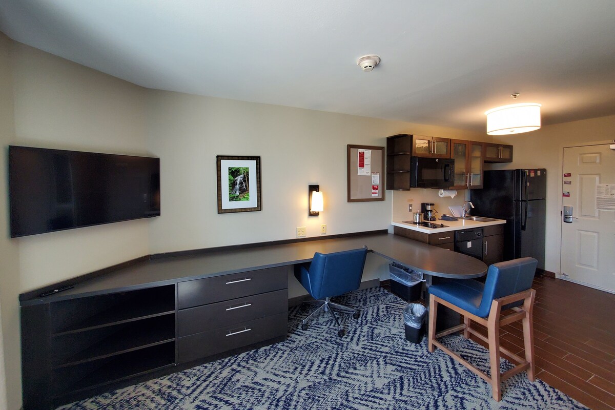 A compact kitchen with a microwave, refrigerator, and a dining area with a table and chairs.