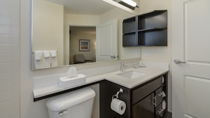 A modern bathroom with a white sink, a mirror, and a toilet.