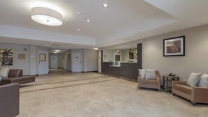A spacious lobby with a reception desk, seating area, and a clear path leading to the exit. - Candlewood Suites Mishawaka North by IHG (Mishawaka)