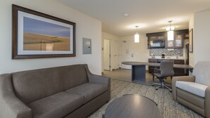 A modern living room with a sofa, a coffee table, and a painting on the wall.