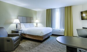 A hotel room with a bed, two bedside lamps, a desk, a chair, a TV, and a window with curtains. - Candlewood Suites Lakeville I-35 by IHG (Lakeville)