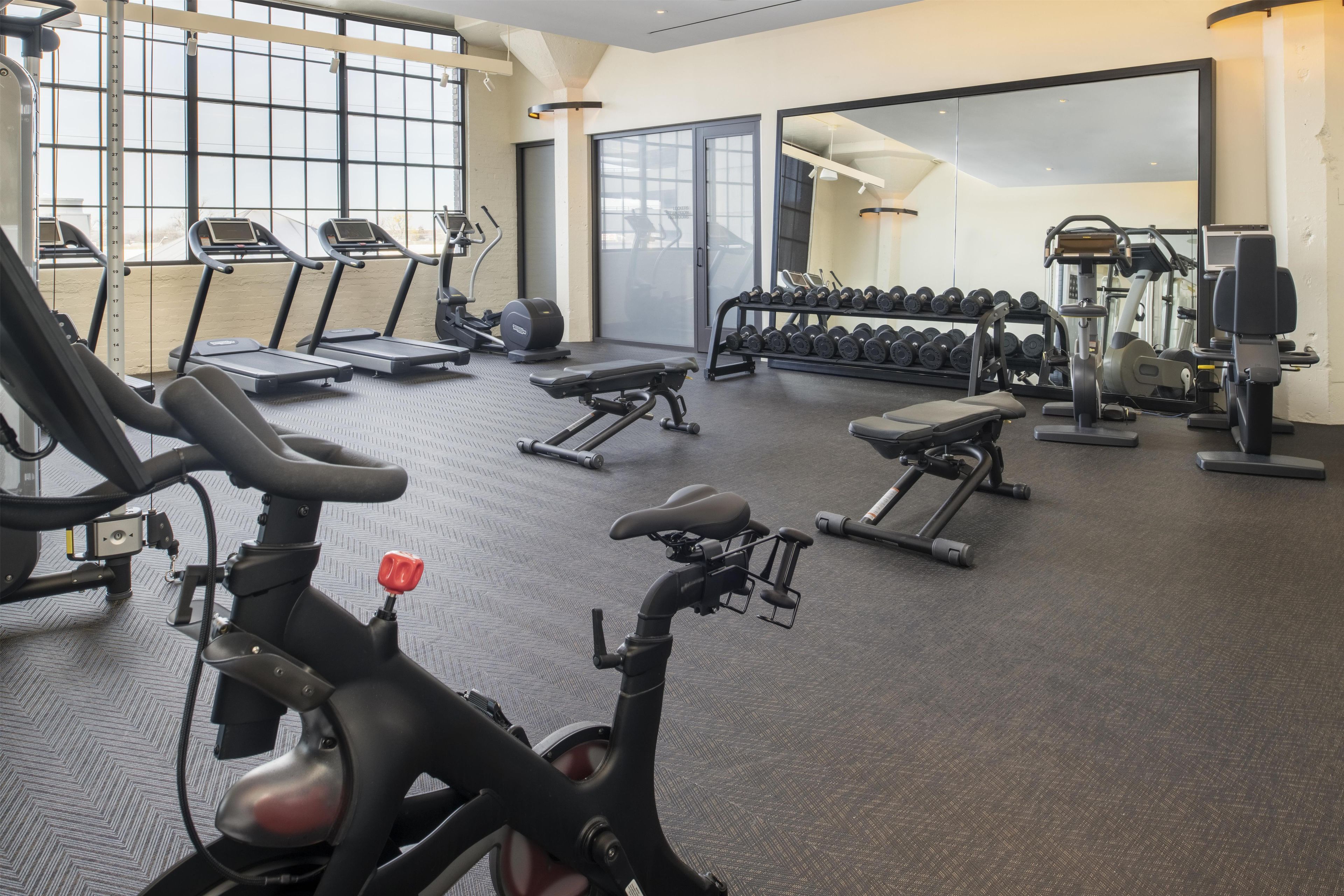 A gym with treadmills, elliptical machines, and weightlifting equipment.