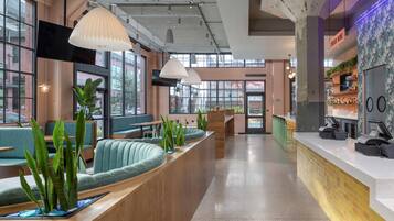 A modern bar area with seating, bar counter, and a view of the street.