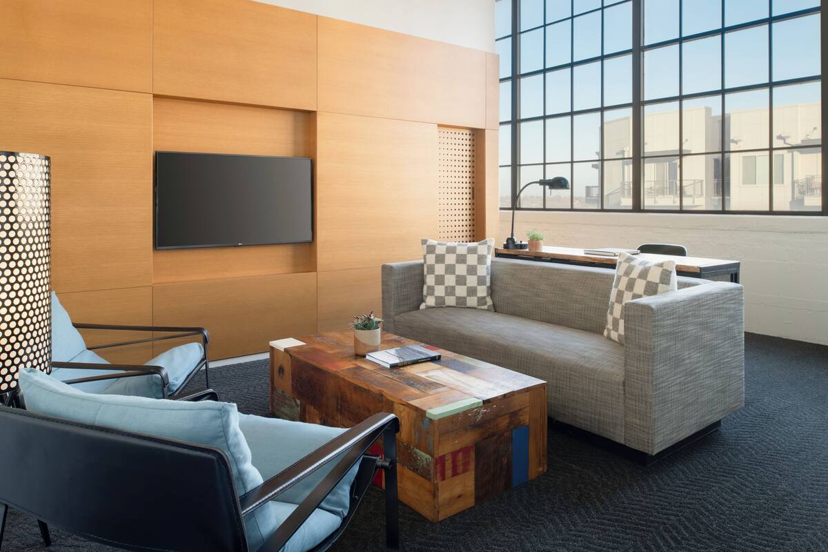 Una habitación moderna con sofá, sillón y una mesa de centro de madera.