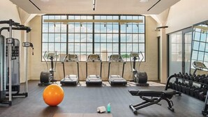 Ein Fitnessstudio mit Laufbändern, Crosstrainern und Kurzhanteln.