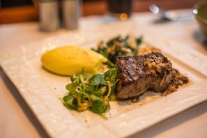 A plate with a steak, mashed potatoes, and a green salad. - Green Empire Resort (Siem Reap)