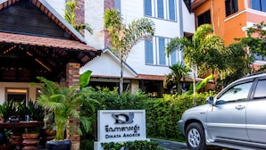 Une enseigne indiquant « Dinata Angkor », avec une voiture garée à proximité.