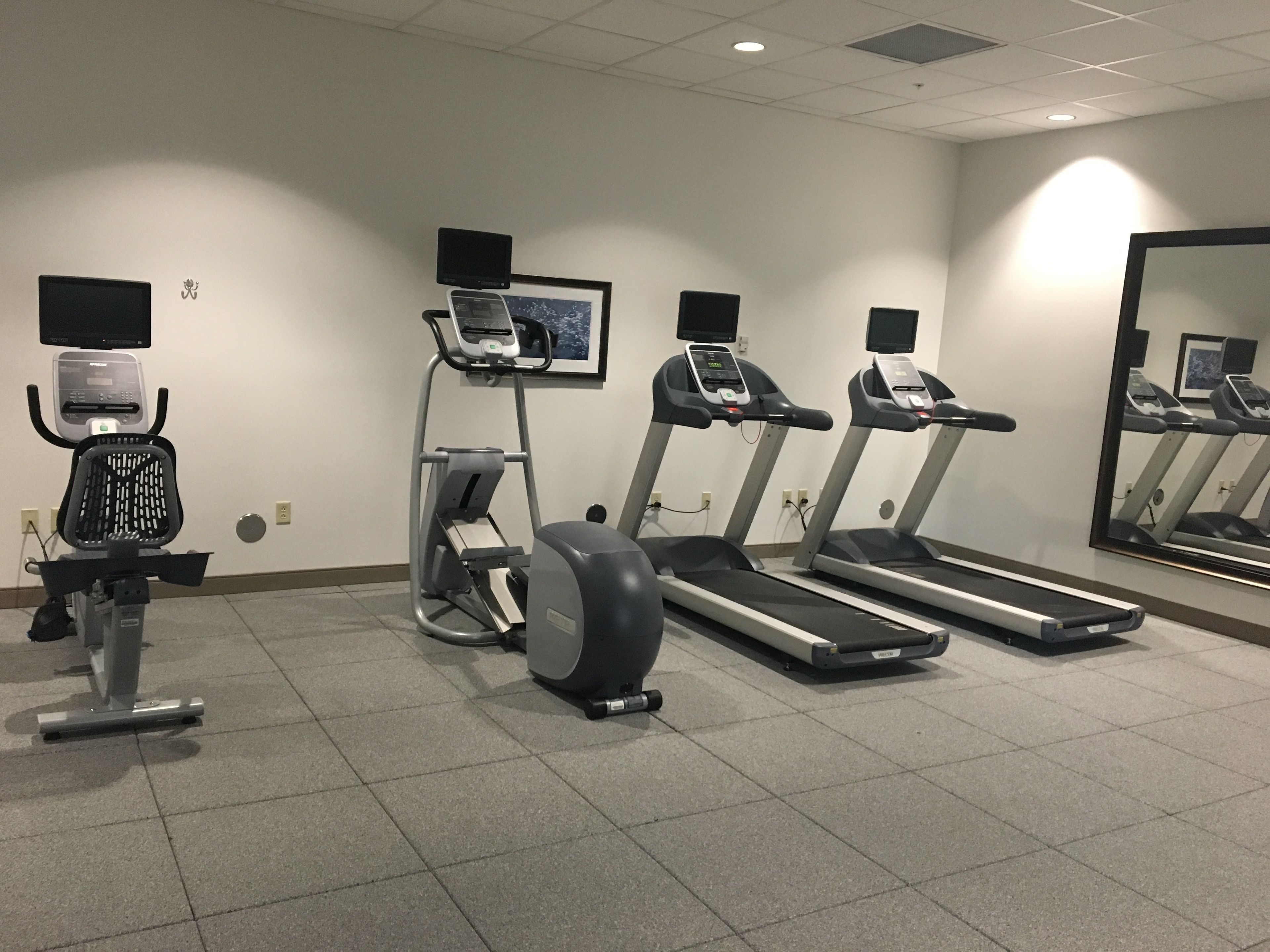 A fitness room with treadmills, a stationary bike, and a rowing machine.