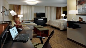 A hotel room with a bed, a desk with a laptop, a TV, and a sofa. - Staybridge Suites Miamisburg by IHG (Miamisburg)