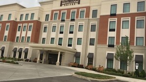 A Staybridge Suites hotel with a modern facade, multiple windows, and a covered entrance area.