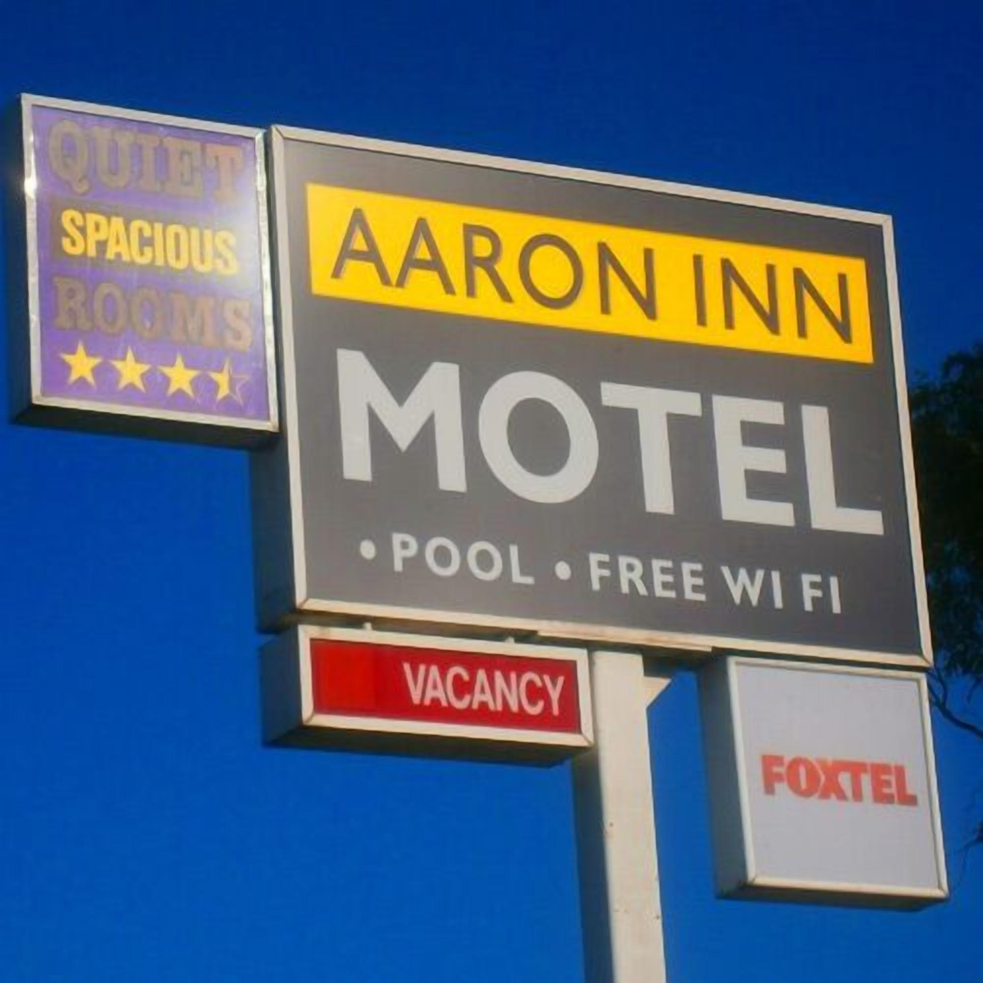 A motel sign with 'Aaron Inn' and 'Motel' prominently displayed, indicating a place offering pool and free WiFi.
