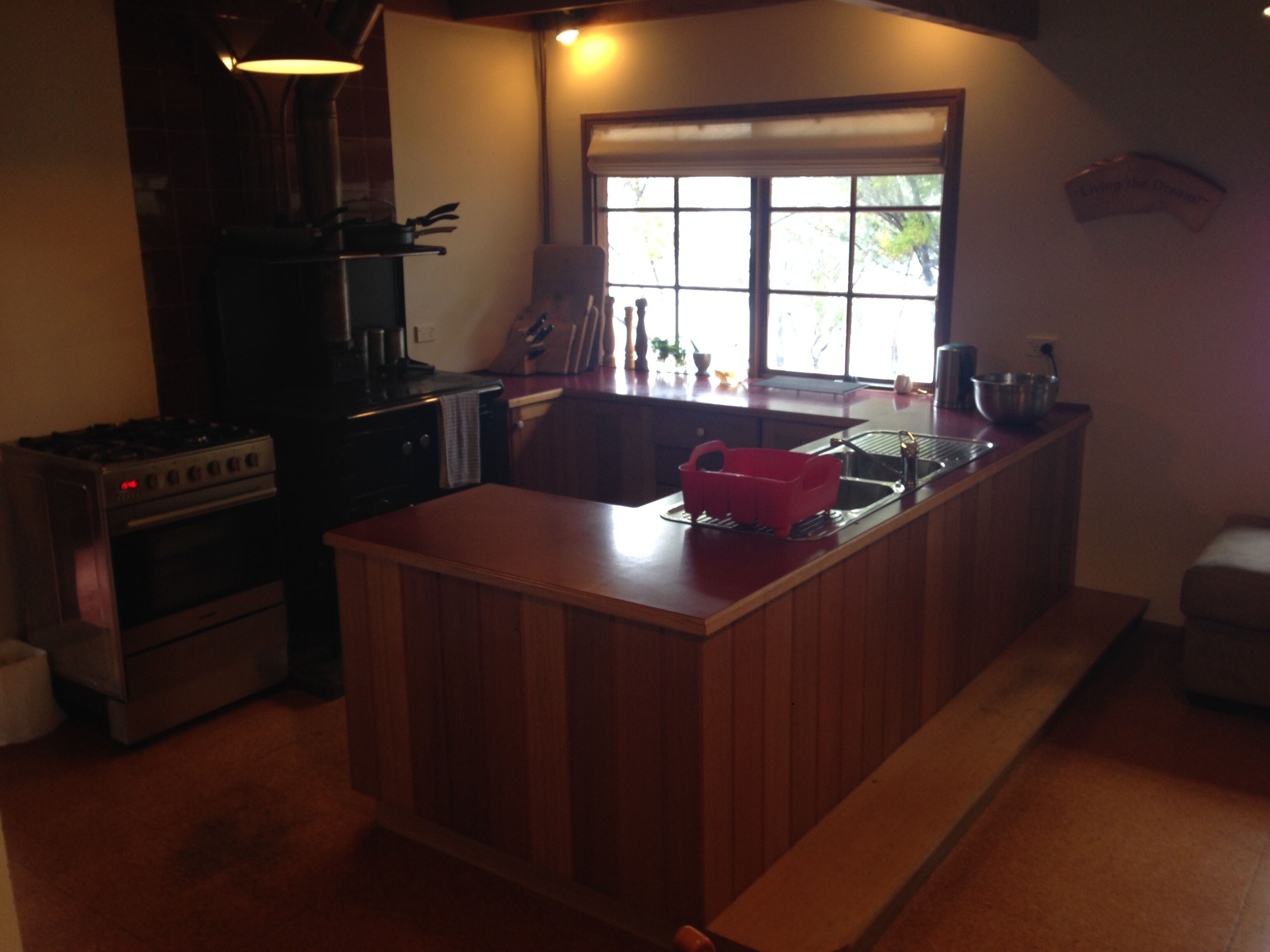A kitchen with a central island, a stove, and a window.