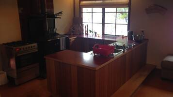 A kitchen with a central island, a stove, and a window.