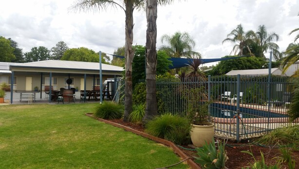 A residential area with a house, a fenced backyard, and a pool. - Sunrise Motel (Barooga)