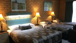 A hotel room with two beds, each with a headboard, bedside tables with lamps, and artwork on the walls. - Sunrise Motel (Barooga)