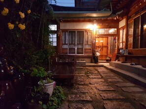 A traditional Japanese building with a wooden exterior, a stone pathway leading to the entrance, and potted plants. - Gongsimga Hanok Guesthouse (Seoul)