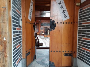 A traditional wooden entrance with a tiled floor and a view into a building with a tiled roof. - Gongsimga Hanok Guesthouse (Seoul)