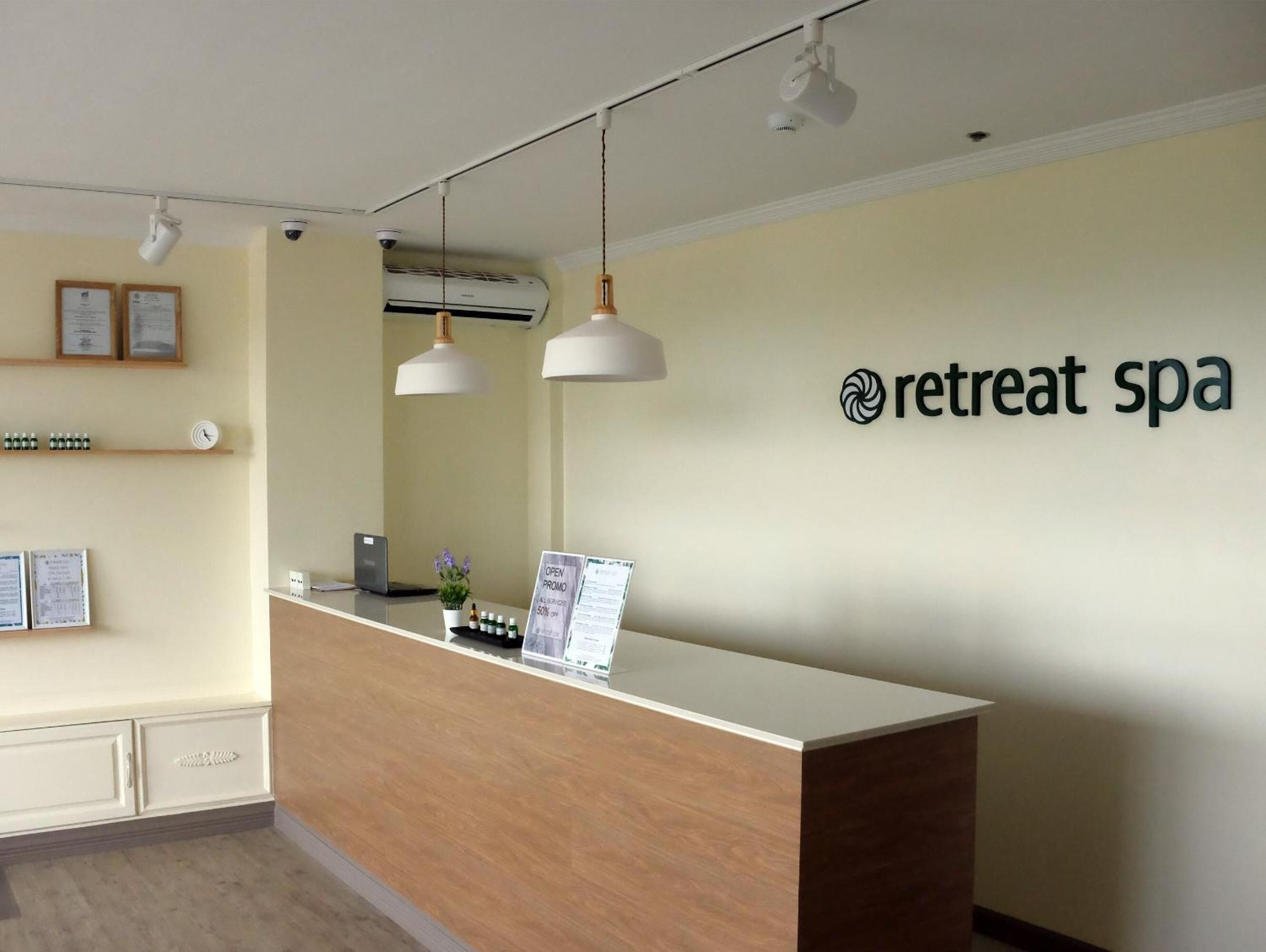 A reception desk with a sign reading "retreat spa" and a clock on the wall.
