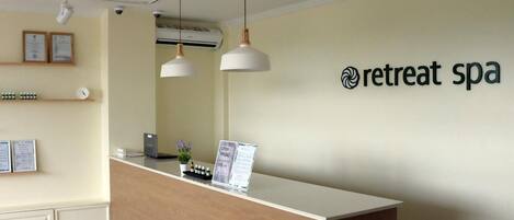 A reception desk with a sign reading "retreat spa" and a clock on the wall.