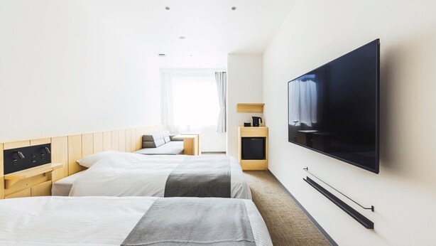 A hotel room with two beds, a TV, a coffee machine, and a small table. - HOTEL NUPKA (Obihiro)