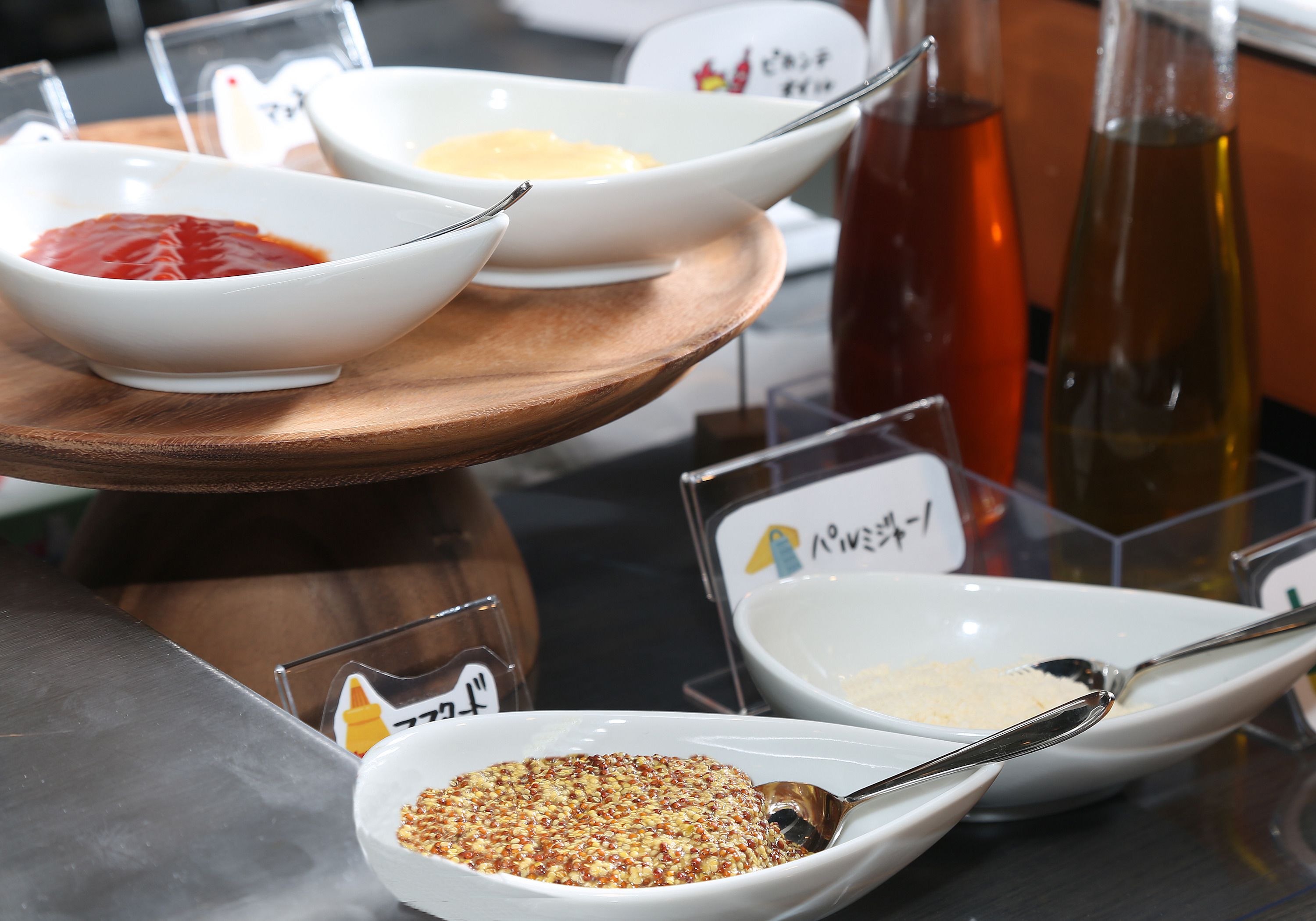 A table with various condiments and a bottle of oil.