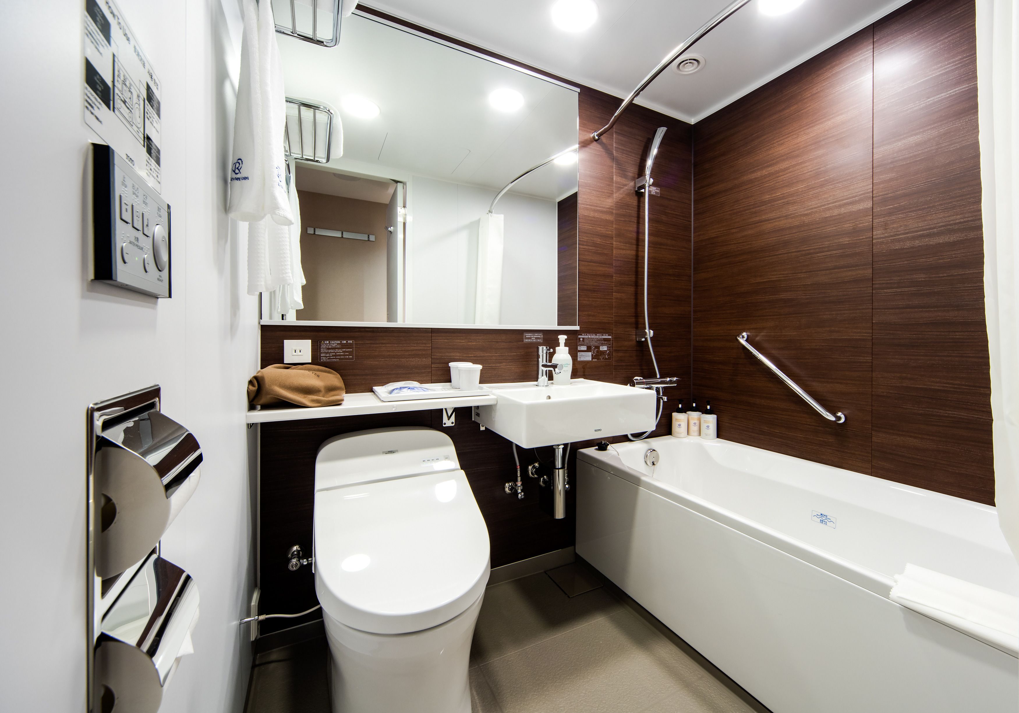 A modern bathroom with a toilet, sink, and bathtub.