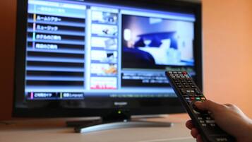 A television with a remote control in front of it.