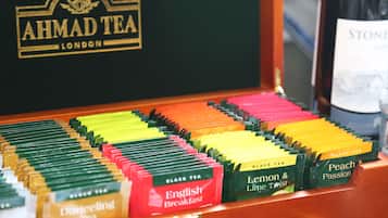 Une sélection de sachets de thé de différentes couleurs, comprenant des variétés comme le Darjeeling, l’English Breakfast, le thé au citron et au citron vert, le thé noir et le thé à la pêche et aux fruits de la passion.
