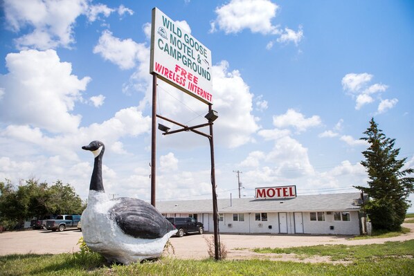 A motel with a sign advertising free wireless internet, a goose sculpture, and a clear blue sky. - Wild Goose Motel and Campground (Kerrobert)
