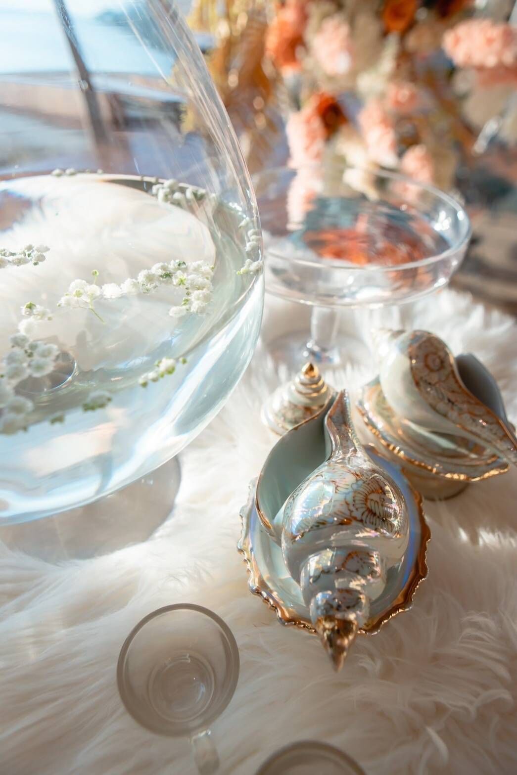 Un cuenco de vidrio con borde festoneado, una concha decorativa y vidrio transparente.