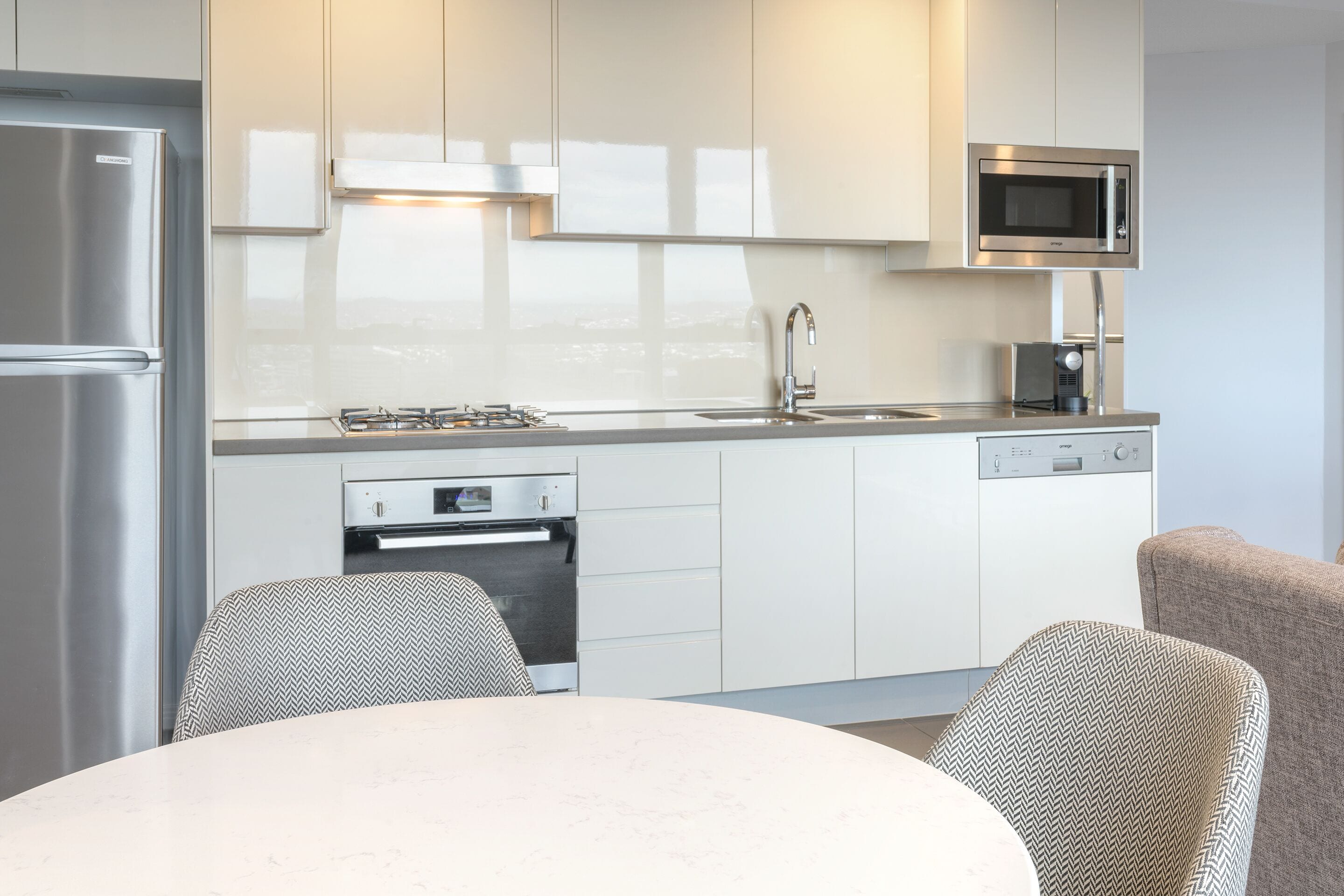 Una cocina moderna con microondas integrado, electrodomésticos de acero inoxidable y lavavajillas.