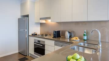 Una cucina moderna con elettrodomestici in acciaio inossidabile, lavastoviglie e lavello.